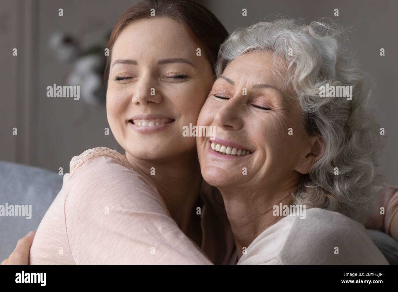 Glückliche ältere Mutter und ältere Tochter umarmen und kuscheln Stockfoto