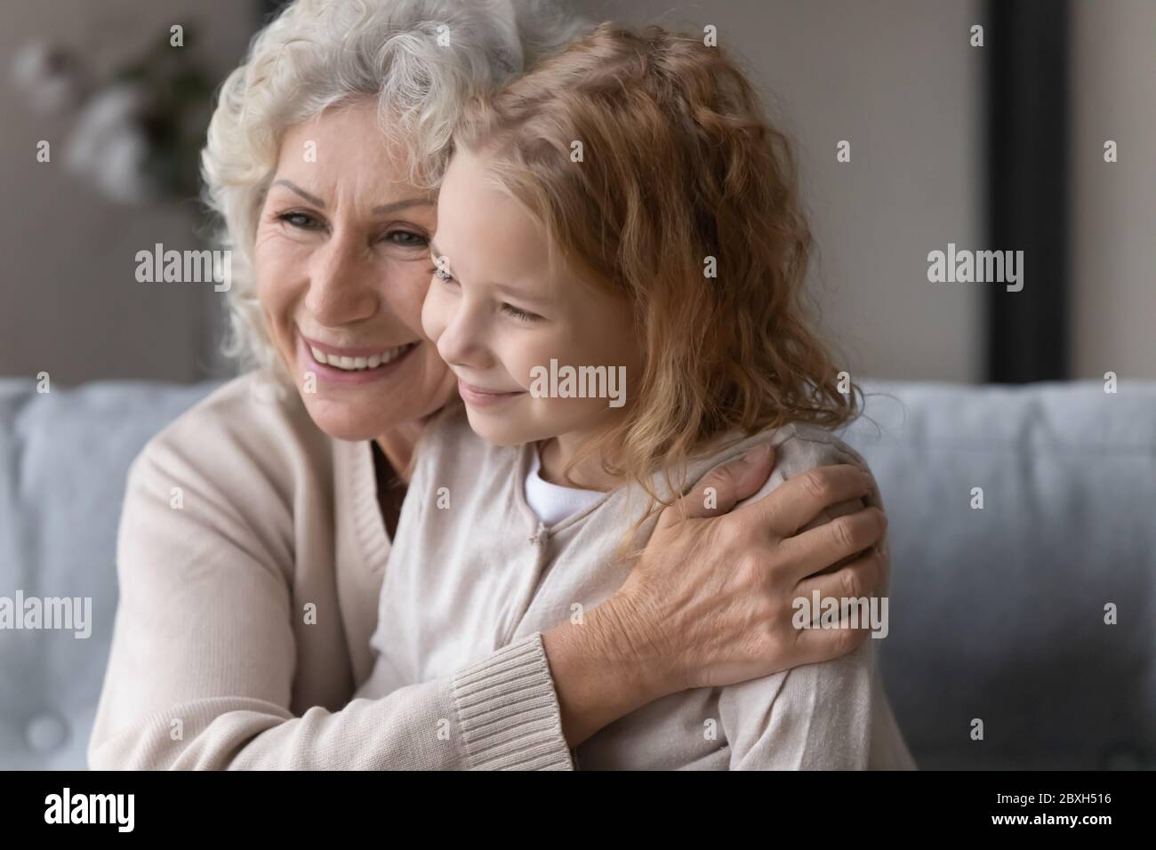 Liebevolle ältere Großmutter Umarmung kuscheln niedlich kleine Enkelin Stockfoto