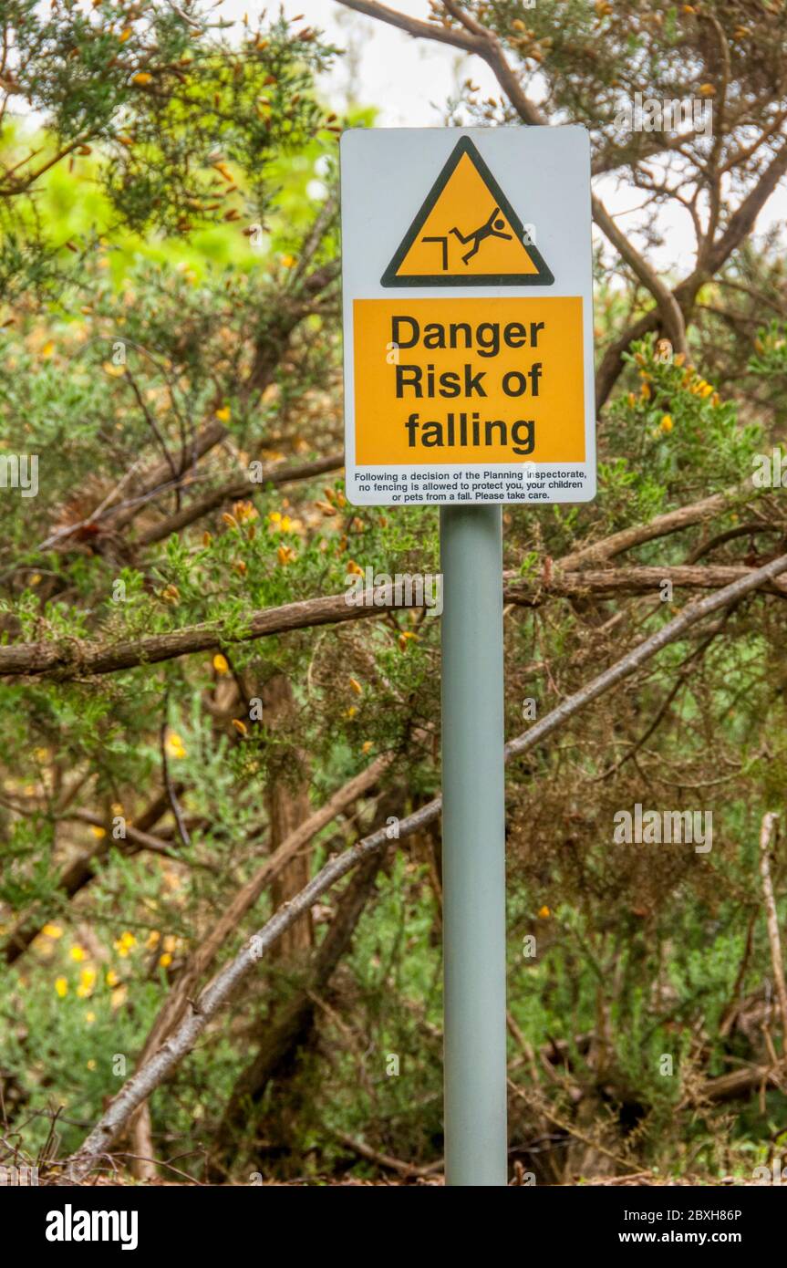 Ein Risiko des Sturzes Zeichen auf den verborgenen Rand eines Steinbruchs in Wald. Stockfoto
