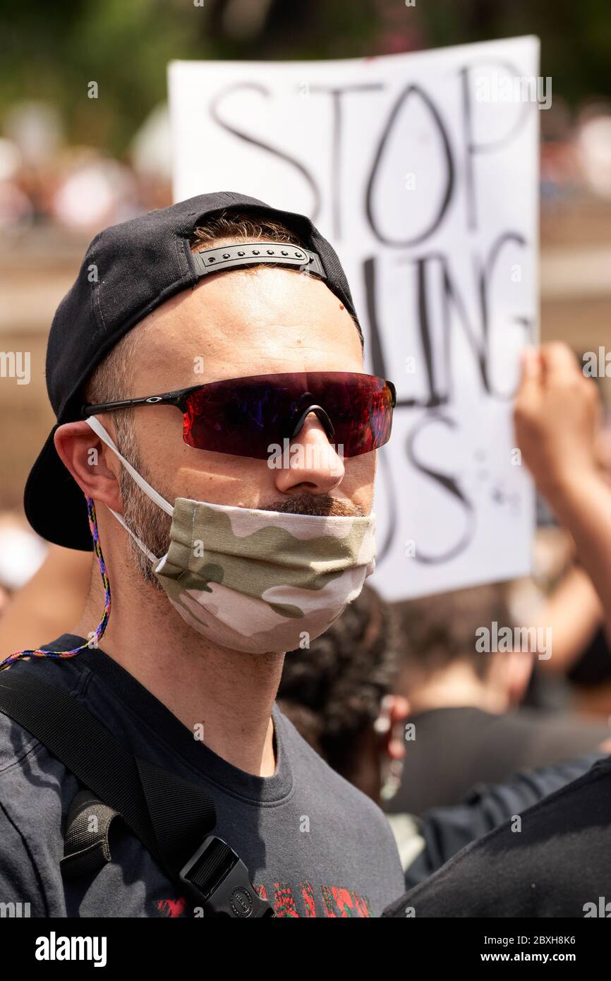 Schwarze Leben sind wichtig, Protest für George Floyd gegen Rassismus. Junger Mann mit einer Tarnmaske im Camouflage-Stil, einer militärisch-ähnlichen Sonnenbrille und einer Baseball-Kappe Stockfoto