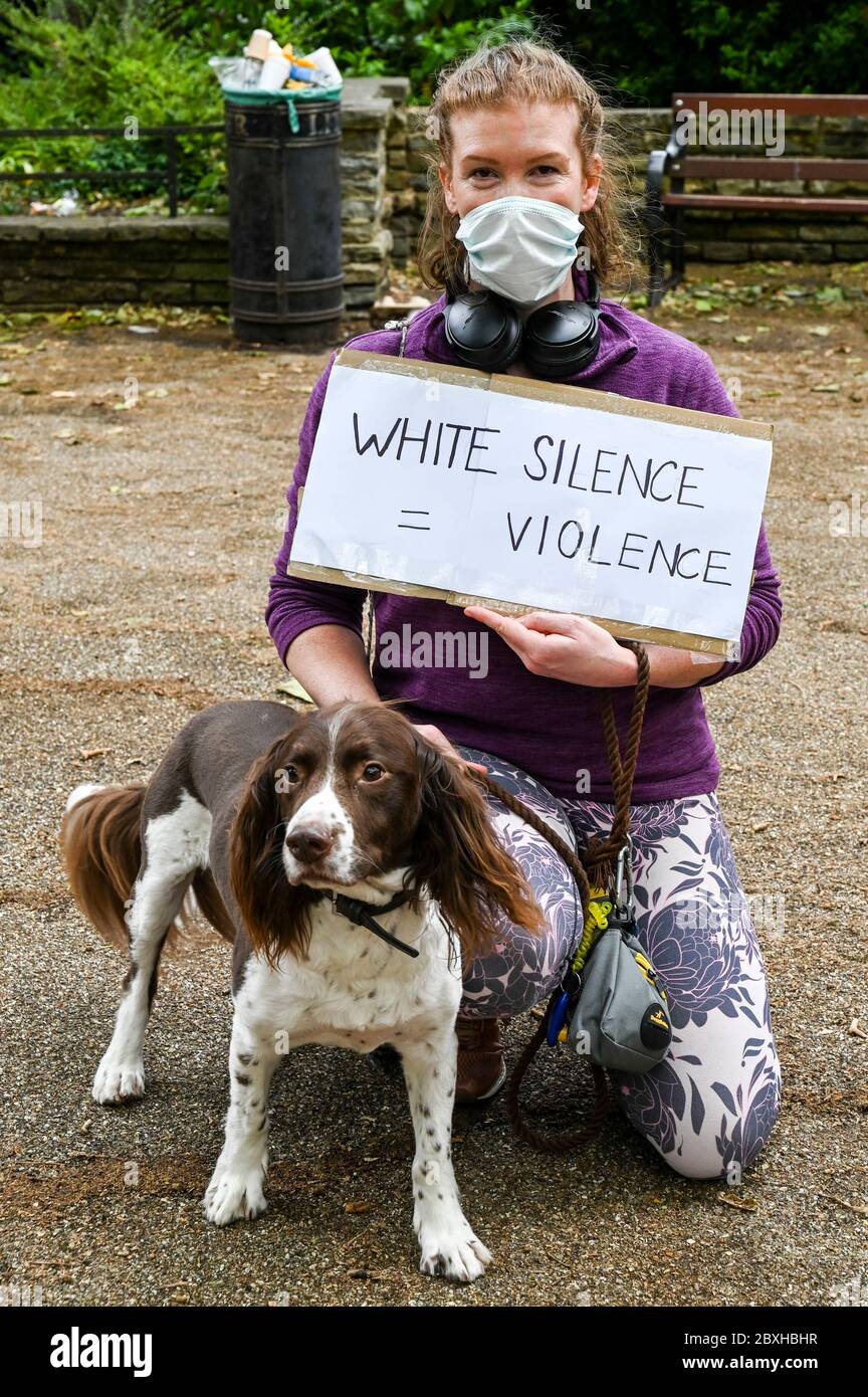 Eine junge weiße Frau in einer Maske mit Hund und Plakat, 'White silence = Violence' bei einer Demonstration zur Unterstützung von 'Black Lives Matter'. London, Großbritannien. Stockfoto