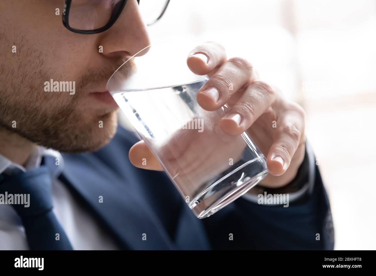 Nahaufnahme des Menschen trinken reines Mineralwasser aus Glas Stockfoto