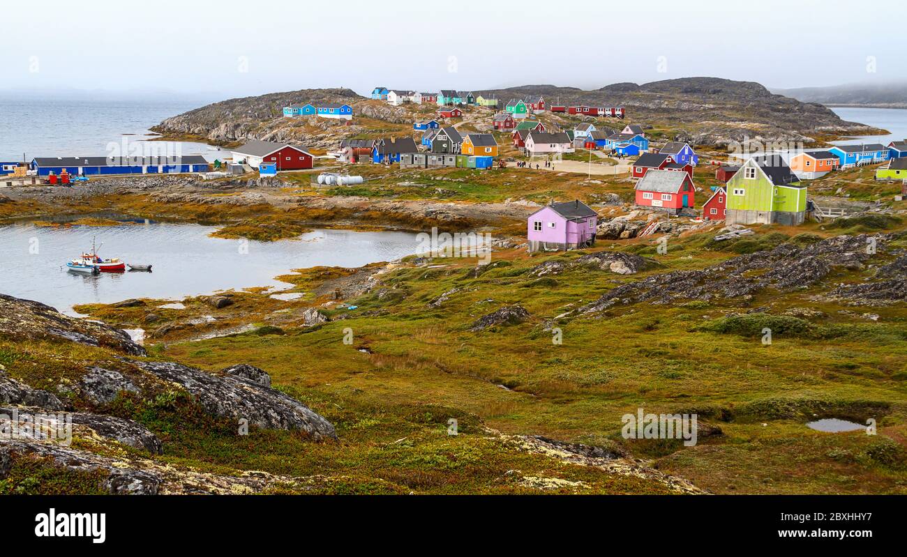Bunt bemalte Häuser von Itilleq klettern auf niedrige Hügel rund um den Stadthafen. Es handelt sich um ein Dorf mit 85 Inuit-Einwohnern an der Südwestküste Grönlands. Stockfoto