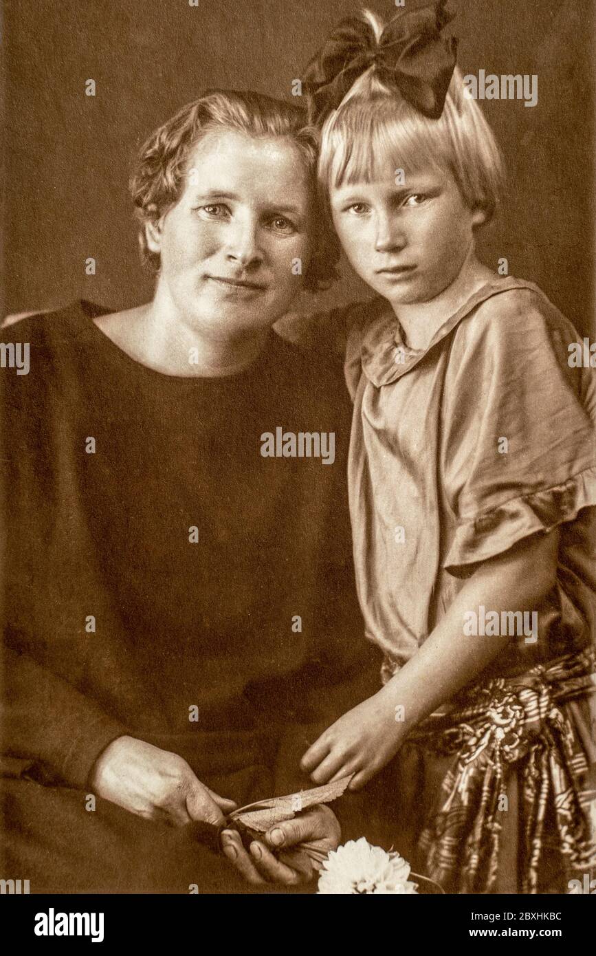 Deutschland - UM 1930er Jahre: Porträt von Mutter und Tochter auf Bank im Studio sitzen, Vintage Carte de Viste Art Deco-Ära Foto Stockfoto