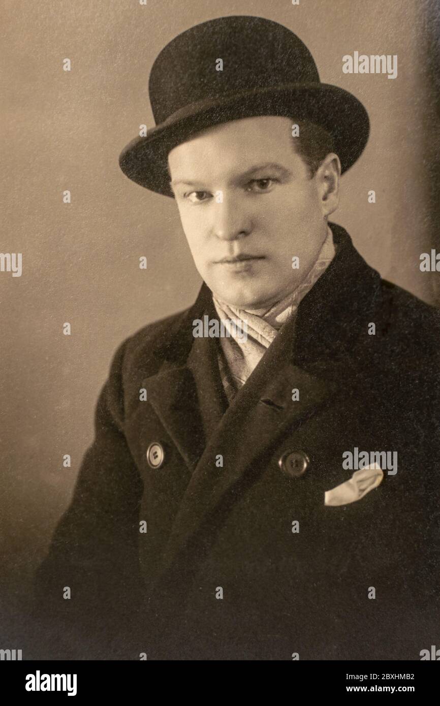 Deutschland - UM 1930er Jahre: Mann im Mantelportrait im Atelier. Nahaufnahme. Vintage Art Deco Ära Foto Stockfoto