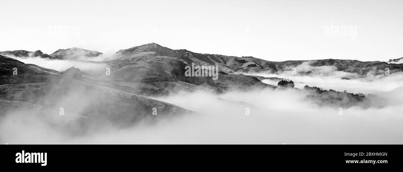 Silhouette der Berge in der nebligen Morgen. Blick auf die Berge im frühen Winter. Wunderschöne Naturlandschaft. Bank Peninsula, Robinsons Bay, Canter Stockfoto