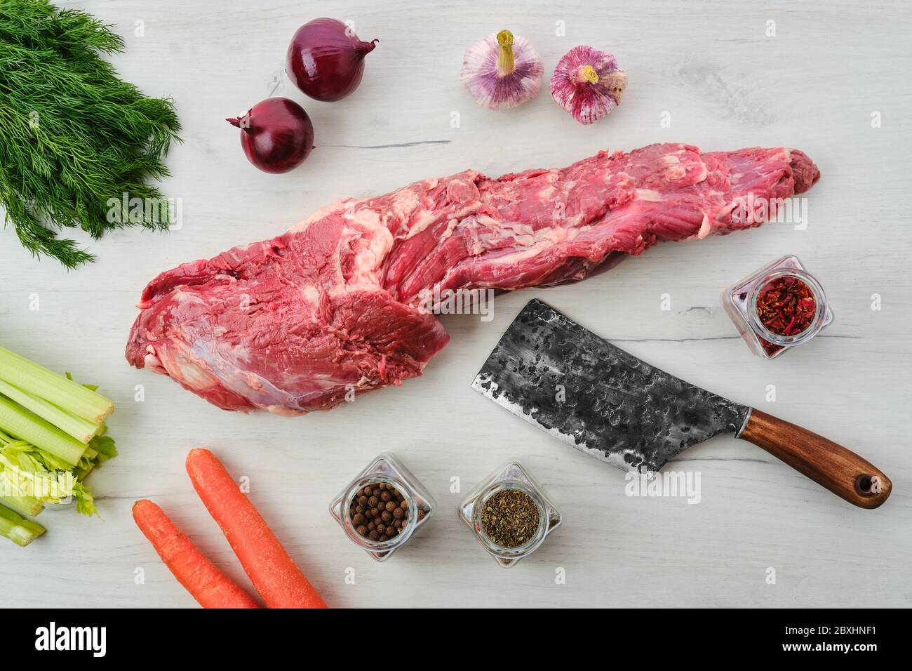 Rohes frisches Rindfleisch ganze Filet mit Gewürzen und Kräutern auf Holzhintergrund Stockfoto