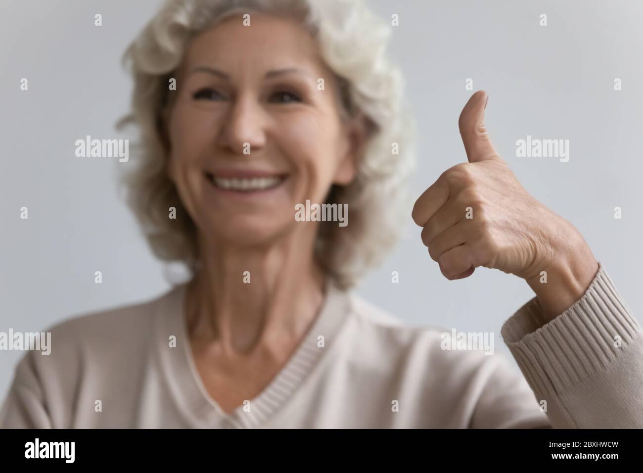 Lächelnde reife Frau zeigen Daumen nach oben empfehlen guten Service Stockfoto