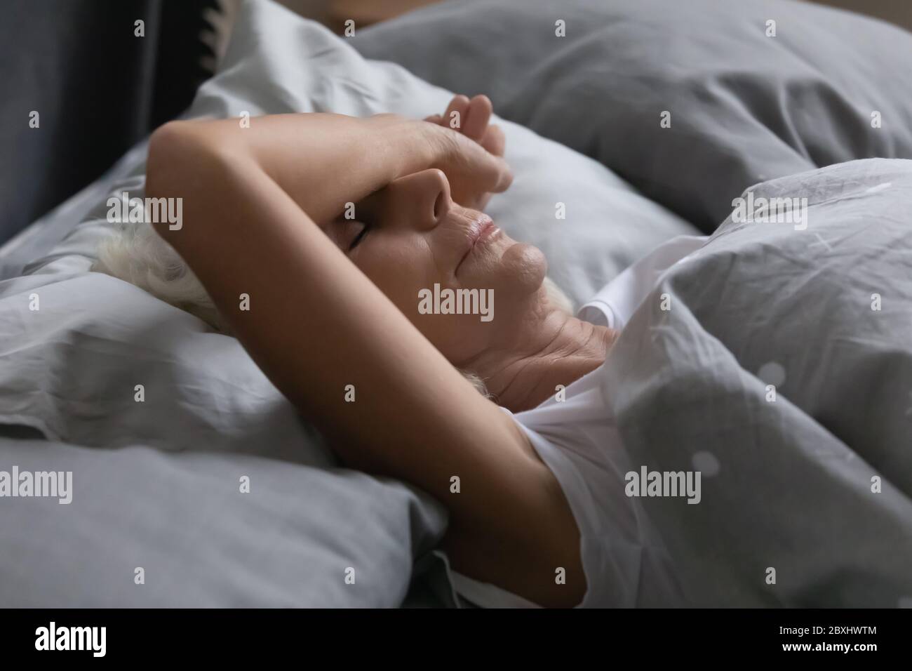 Erschöpft reife Frau schlafen friedlich im Bett Stockfoto