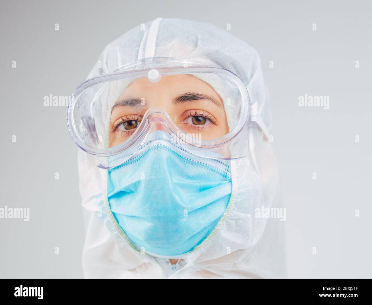 Porträt einer kaukasischen Ärztin mit psa-Anzug, Maske und Brille im Krankenhaus. Coronavirus, Covid-19, globaler Ausbruch, medizinische Maske, Krankenhaus, Stockfoto