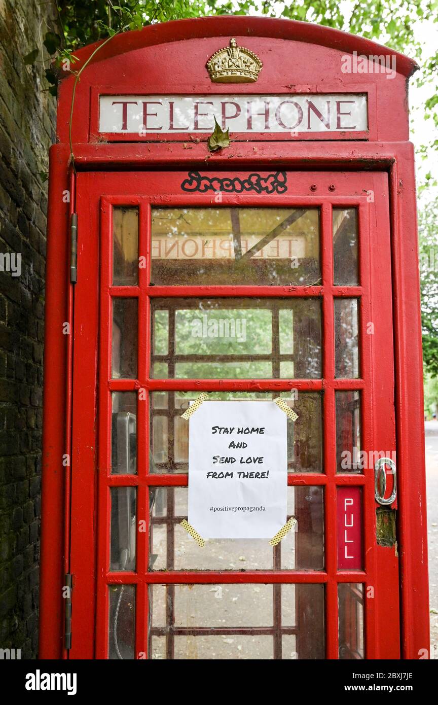 Eine Mitteilung auf einem roten britischen Telefonkasten „Bleiben Sie nach Hause und senden Sie Liebe von dort“. Stockfoto