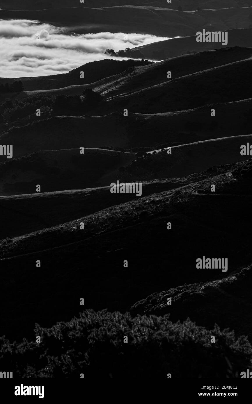 Silhouette der Berge in der nebligen Morgen. Blick auf die Berge im frühen Winter. Wunderschöne Naturlandschaft. Bank Peninsula, Robinsons Bay, Canter Stockfoto