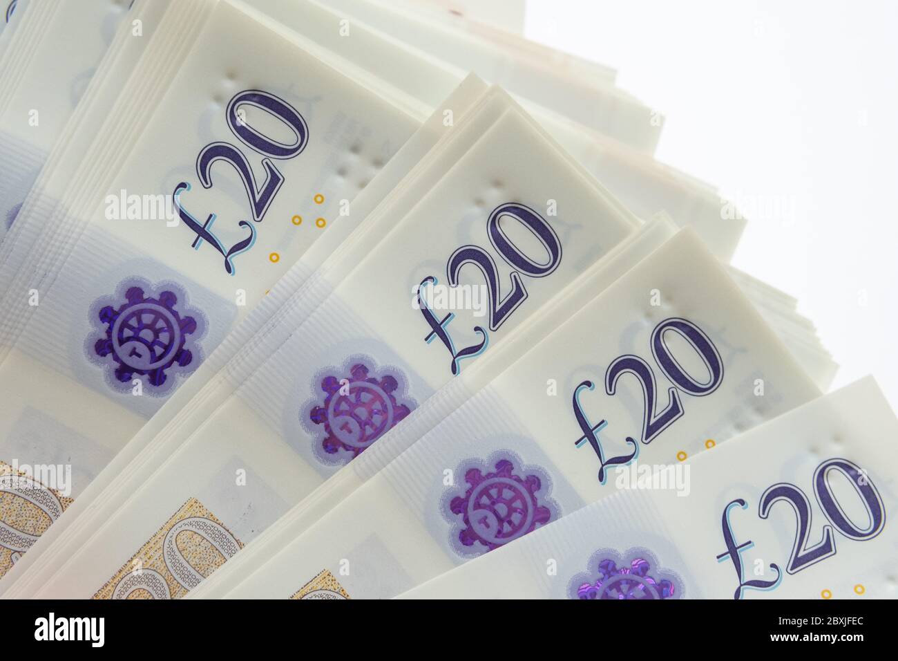 Ecke des Stapels von 20 Pfund Banknoten auf weiß isoliert. Foto von neuen Polymer 20 Pfund Note veröffentlicht im februar 2020 in Großbritannien. Stockfoto