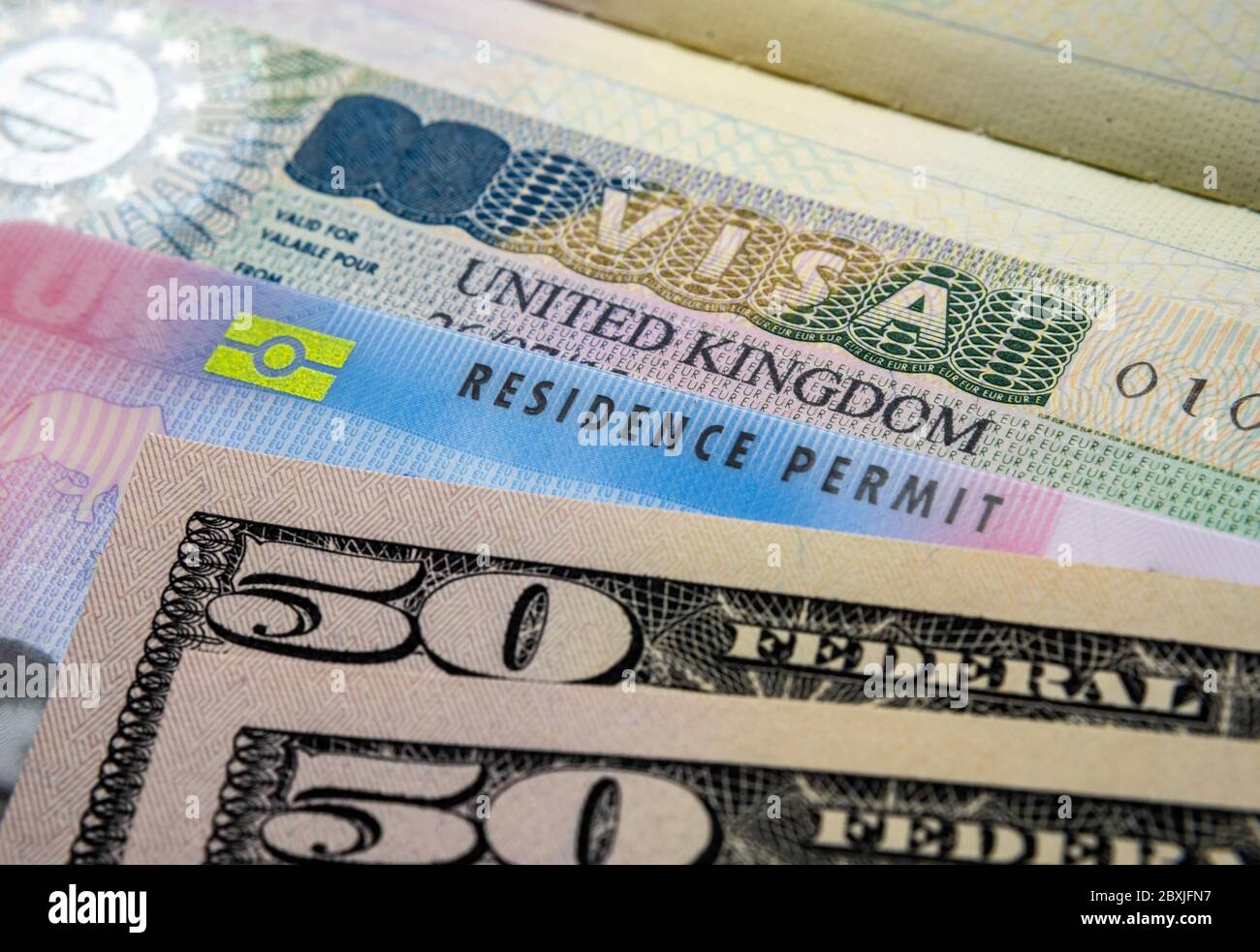 UK Einreise Business Visum im Reisepass, biometrische Aufenthaltserlaubnis Karte und Stapel von 50-Dollar-Banknoten. BRP-Karten für Tier 2 Arbeit Visum Einwanderer freigegeben Stockfoto