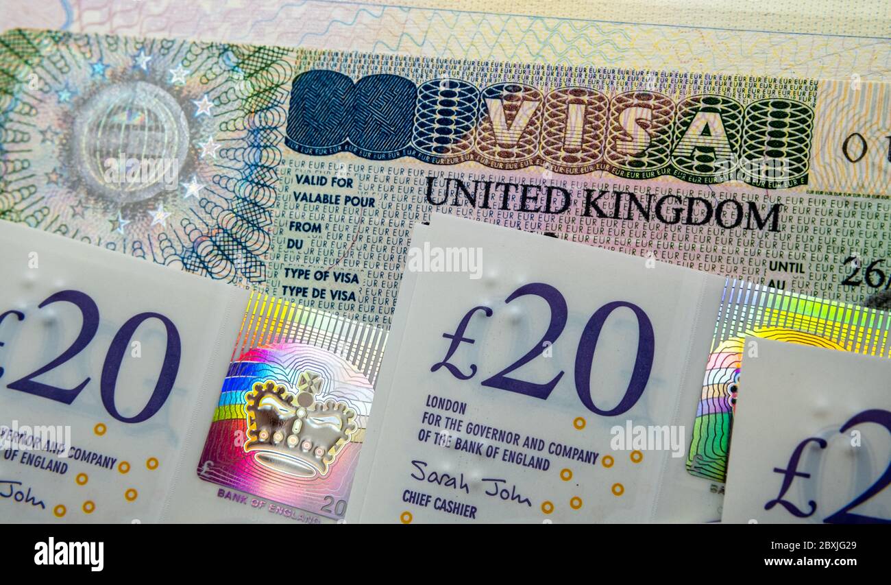 UK Einreise Business-und Touristenvisum im Pass und Stapel von 20 Pfund Banknoten. Konzept Bild für die Kosten des Visums. Stockfoto