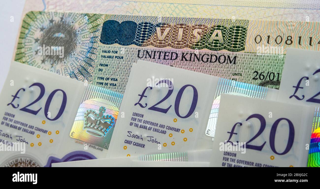 UK Einreise Business-und Touristenvisum im Pass und Stapel von 20 Pfund Banknoten. Konzept Bild für die Kosten des Visums. Stockfoto