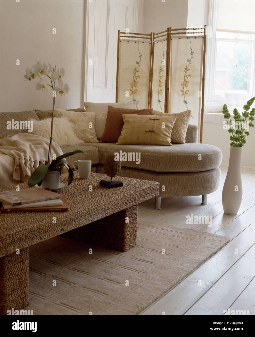 Beigefarbenes Sofa und Kissen in weißem Zimmer Stockfoto