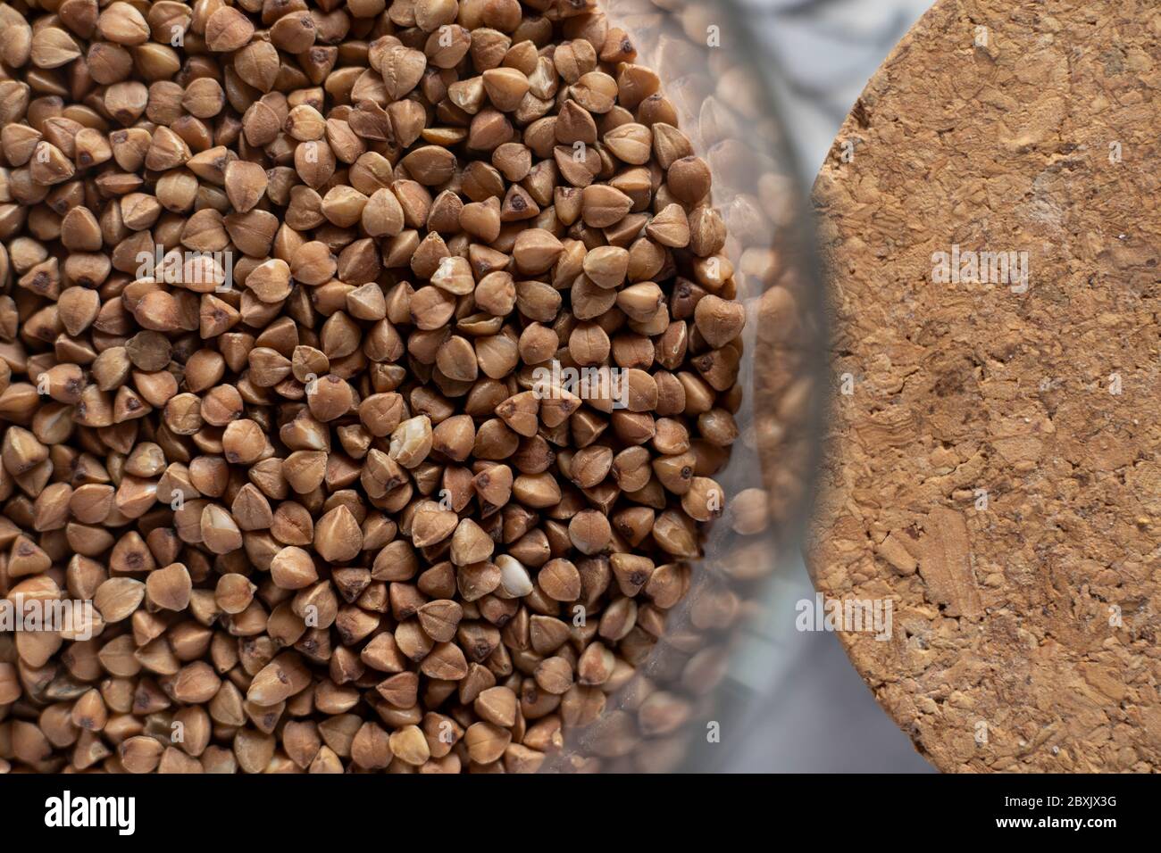 Nahaufnahme Textur von Bio-Buchweizen Grütze in einem Glas und einem Kork Abdeckung Stockfoto