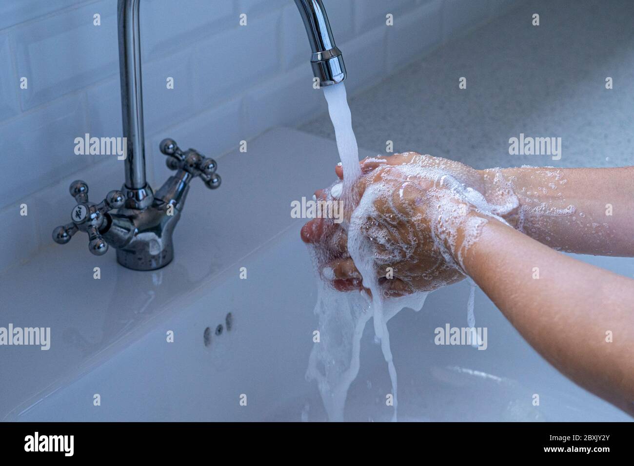 Waschen Sie sich die Hände. Frau, die sich die Hände mit Seife wäscht, um das Covid-19-Infektionsrisiko zu verringern. Stockfoto