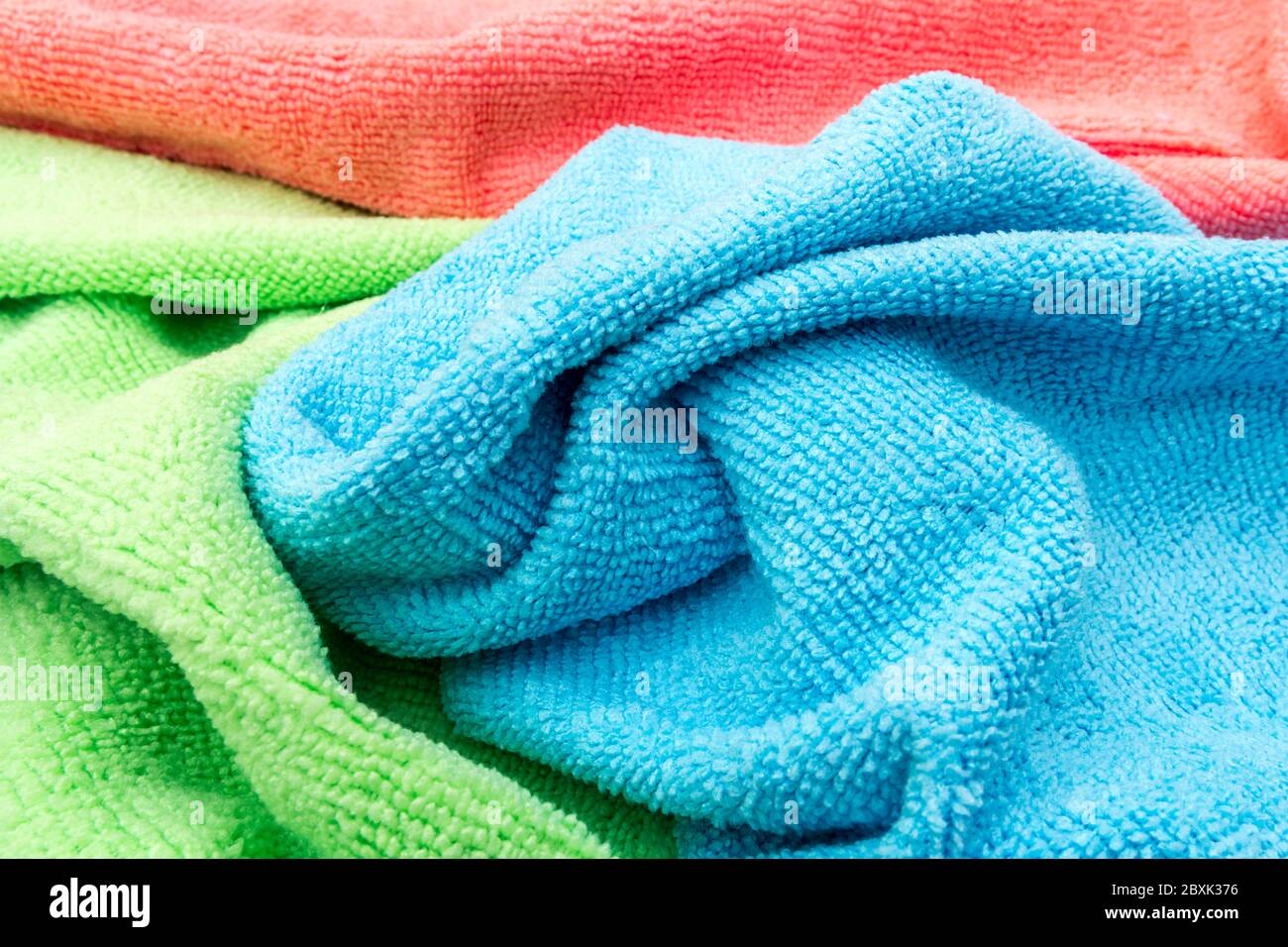 Eine Auswahl an Reinigungstüchern in Orange, Blau und Grün Stockfoto