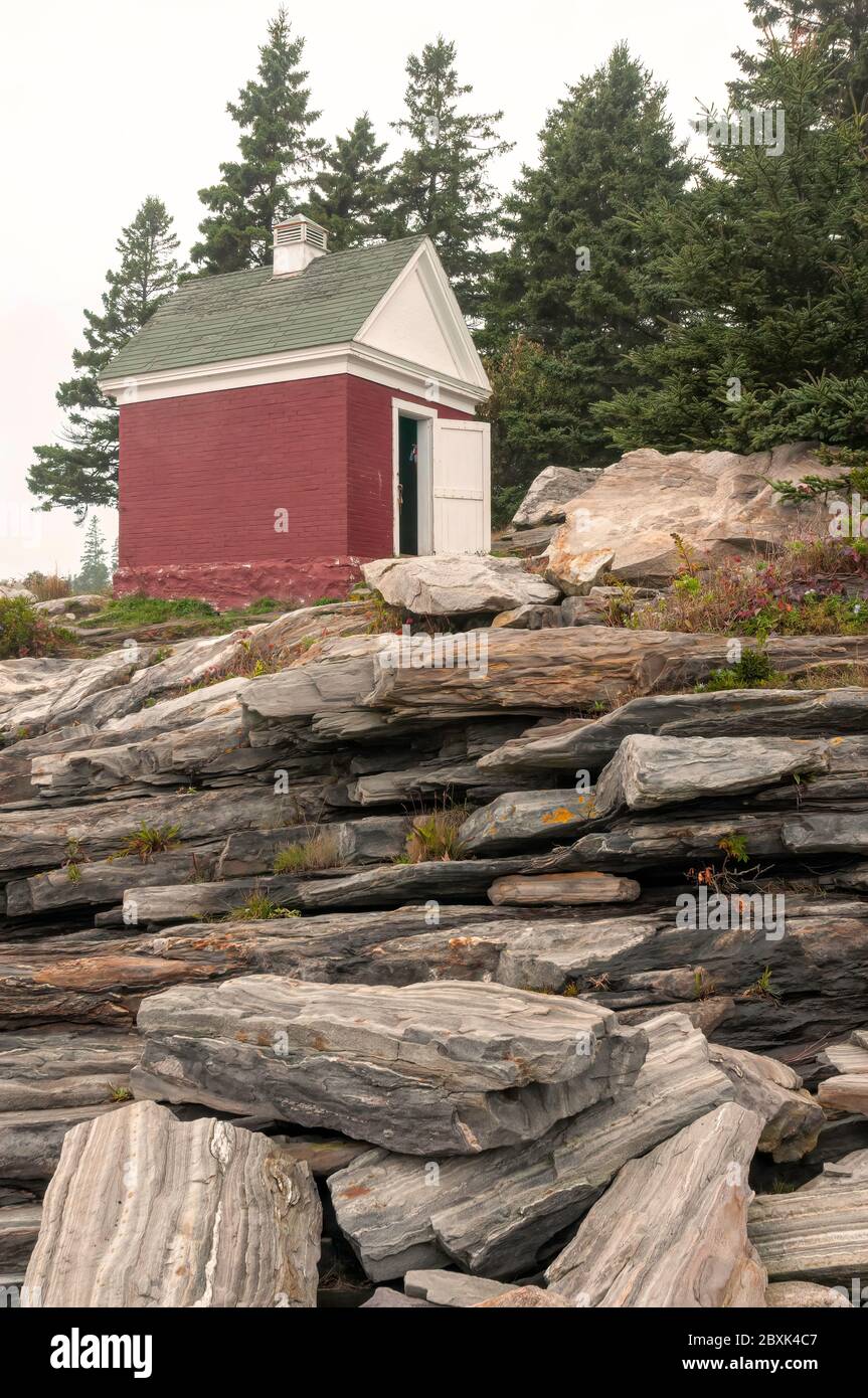 Ölschuppen, verwendet für die Lagerung von Leuchtturmöl, auf den Felsen sitzend, am Pemaquid Point Leuchtturm in Bristol, Maine. Stockfoto
