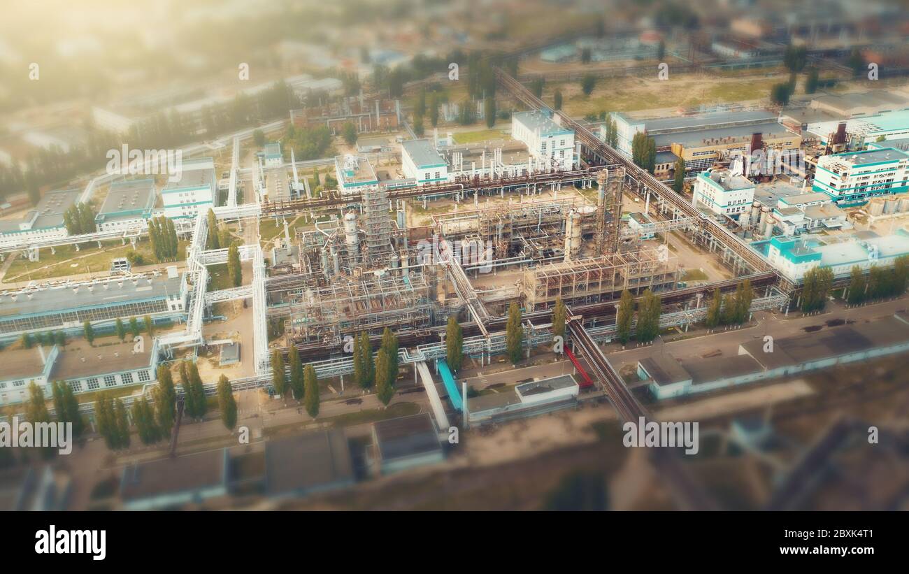 Luftaufnahme der Chemiefabrik mit Tanks Lager Stahl-Pipelines, Industriezone Bereich, Tilt-Shift-Ansicht wie kleine Spielzeuggebäude mit verschwommenem Hintergrund. Stockfoto