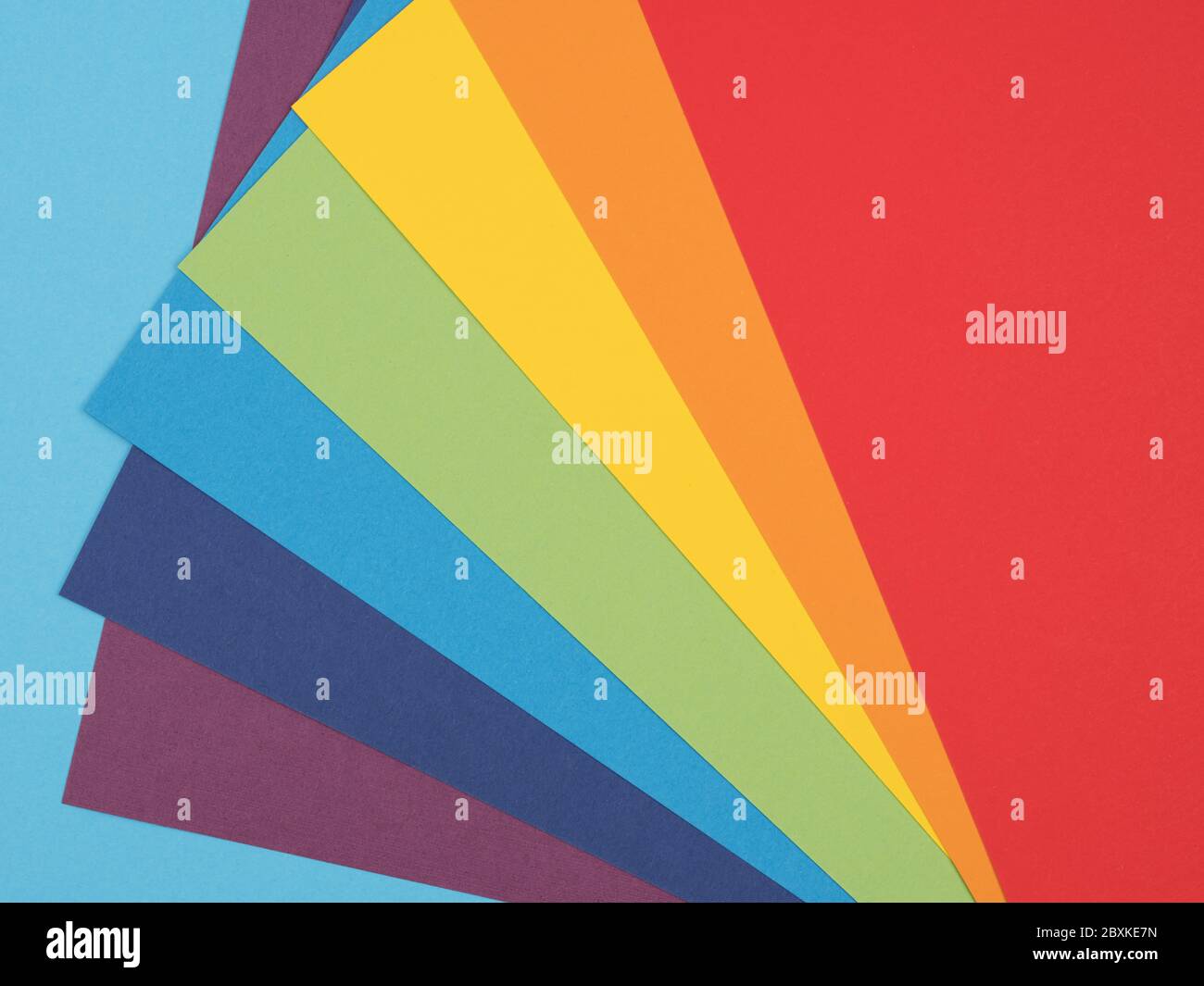 Eine Palette von sieben Farben des Regenbogens auf blauem Hintergrund. Stockfoto