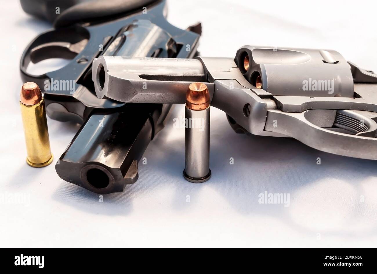 Zwei Revolver, ein 357 Magnum und ein 38 Special mit hohlen Punktkugeln für jeden von ihnen auf weißem Hintergrund Stockfoto
