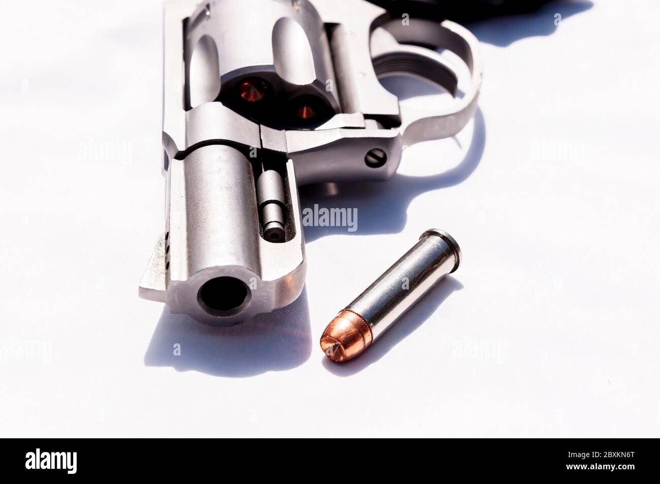 Ein Edelstahl-Snub-Nosed 357 Magnum Revolver mit einem hohlen Punkt Kugel daneben auf weißem Hintergrund Stockfoto
