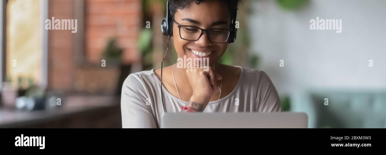 Lächelnde afrikanische Mädchen tragen Kopfhörer Online-Webinar ansehen Verwenden Laptop Stockfoto
