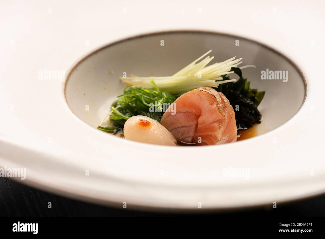 Sashimi Jakobsmuschel japanisches Gericht mit Gemüse auf weißer Keramik moderne moderne Teller Essstäbchen und Tassen Stockfoto