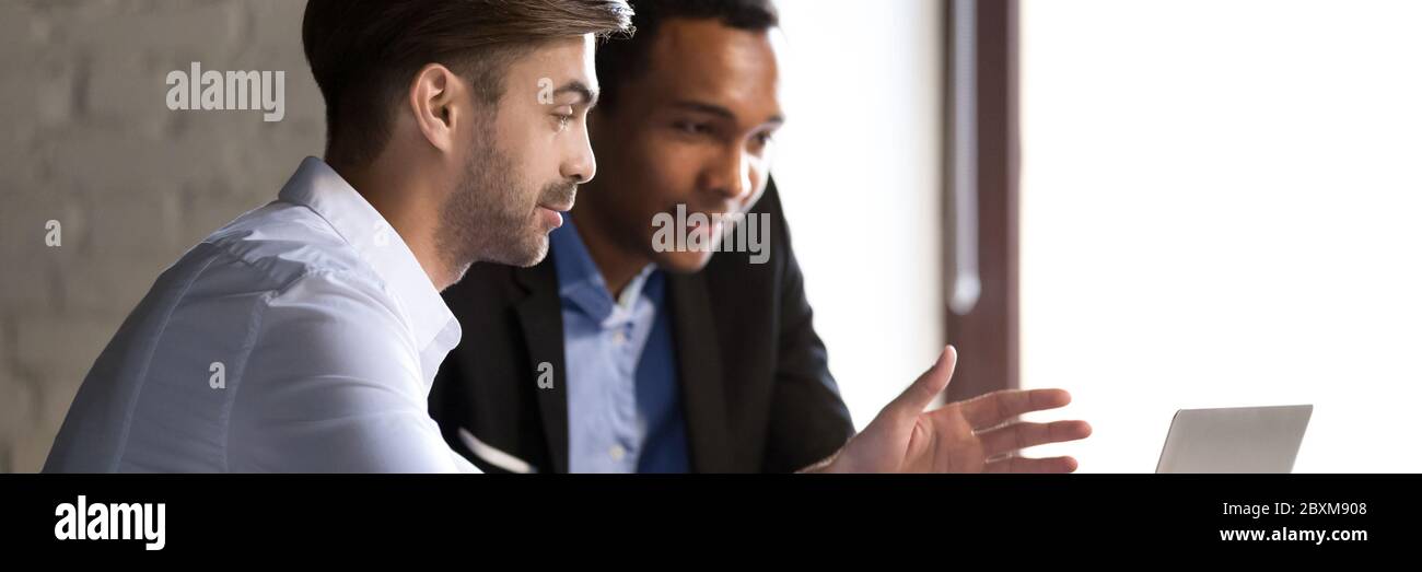 Multiethnische männliche Kollegen tun gemeinsames Projekt während der Besprechung im Büro Stockfoto