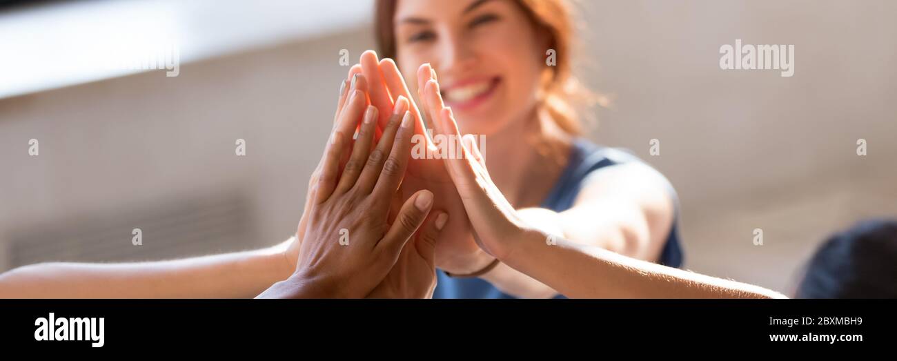 Junge Menschen, die hohe fünf Nahaufnahme Fokus auf gestapelte Handflächen Stockfoto