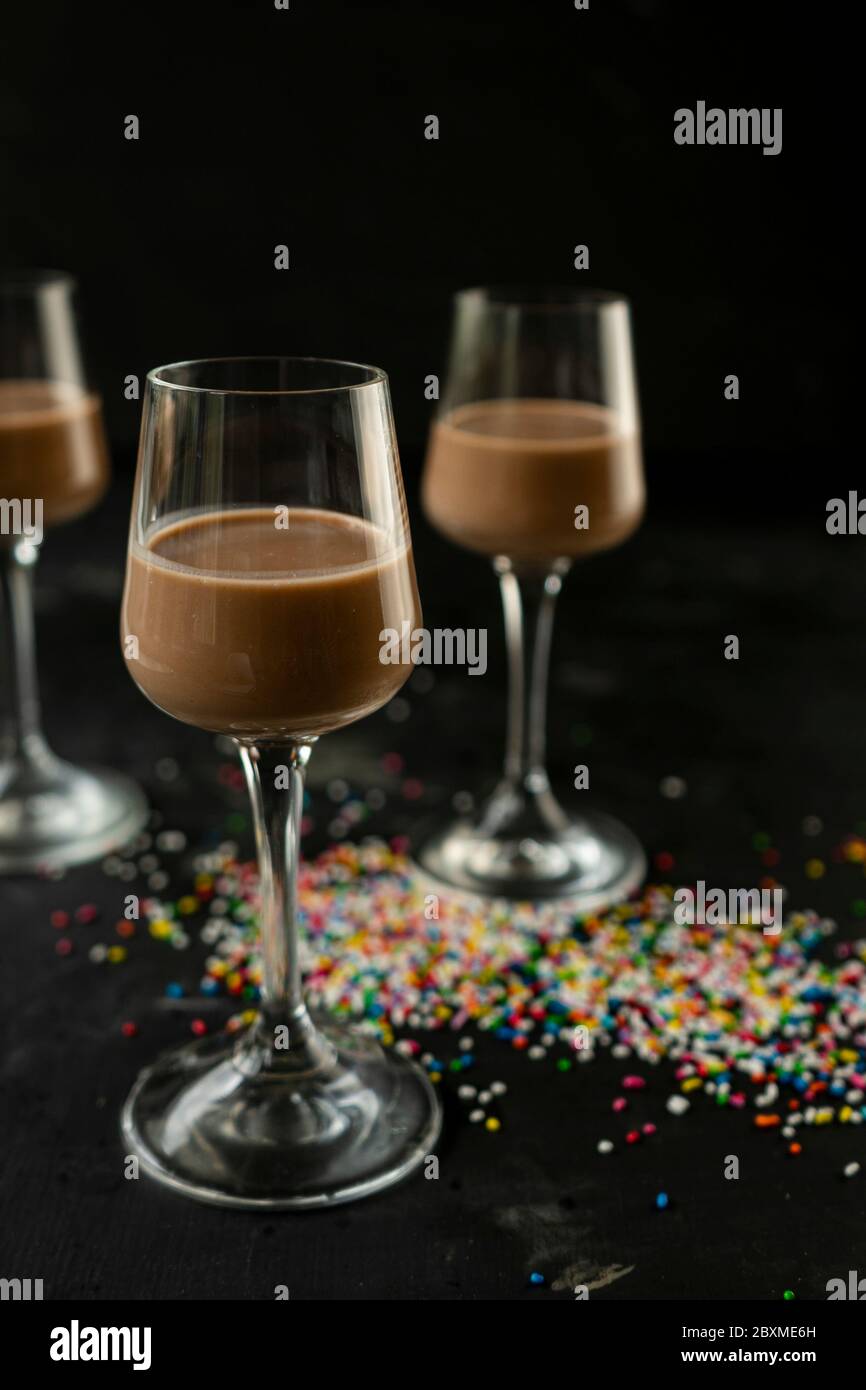 Selektiver Fokus: Schokolade und Kaffeelikör in einem hohen Stapel auf einem dunklen Tisch Stockfoto