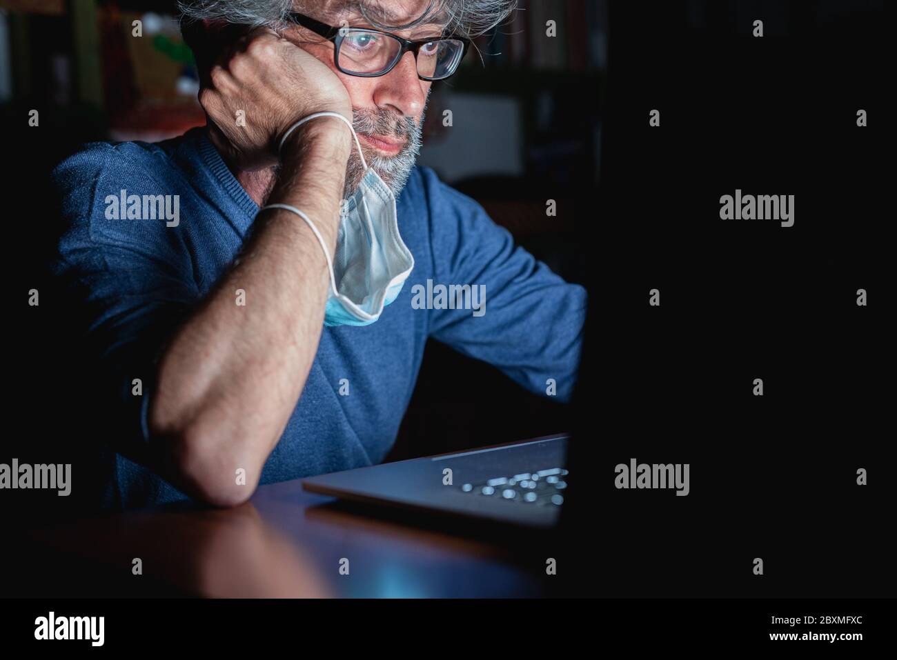 Der reife Mann liest das Online-Bulletin über die weltweite Epidemie, psychische Bedrängnis von Stress, Sorgen und schlechte Nachrichten in der Zeit der Pandemie von C Stockfoto
