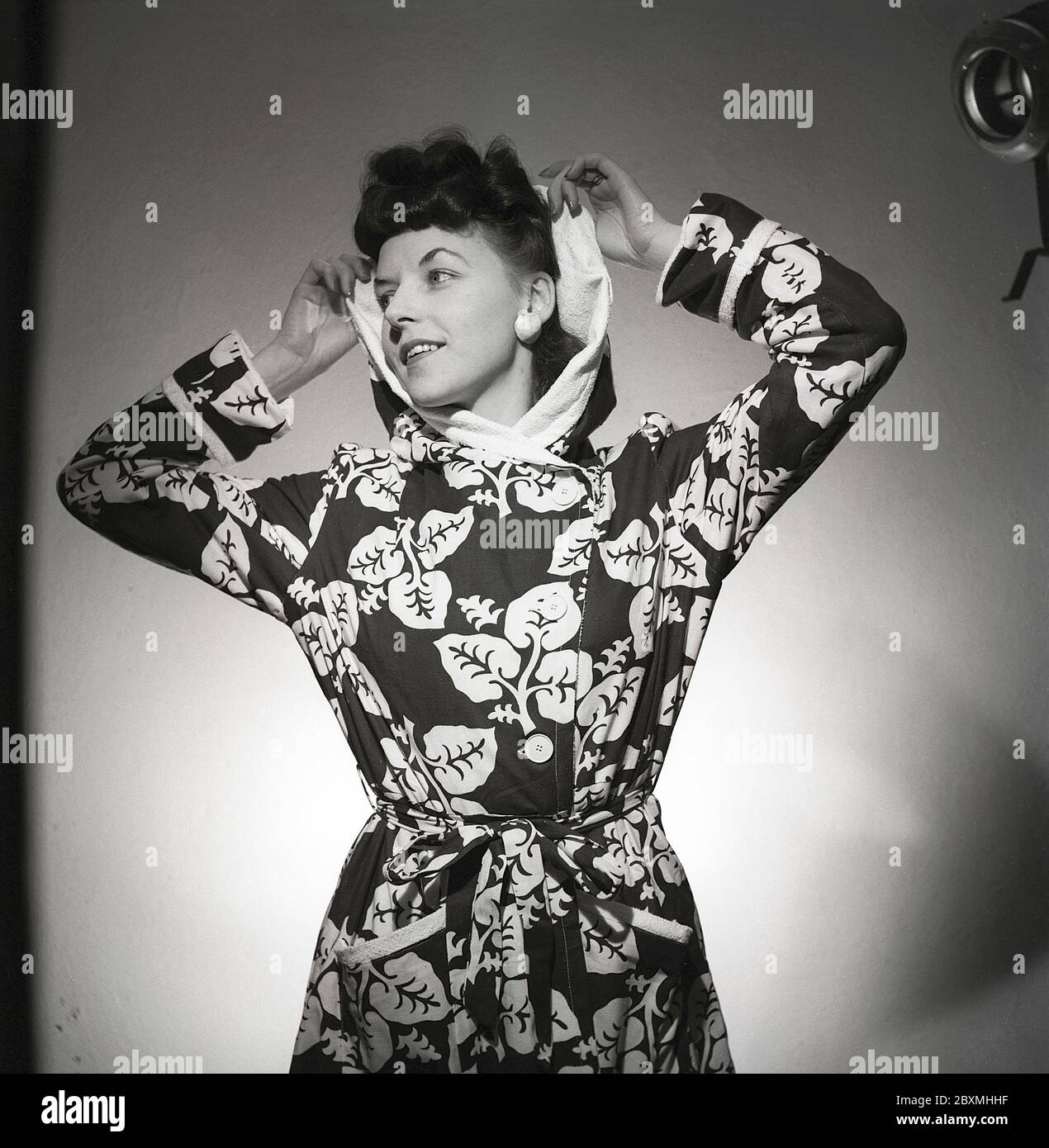 Mode in den 1940er Jahren. Eine junge Frau in einem Fotografen-Studio trägt einen gemusterten Bademantel. Schweden 1946 Kristoffersson Ref. T95-4 Stockfoto