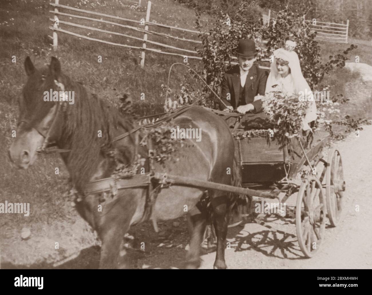 Hochzeitspaar in den 1930er Jahren. Die frisch vermählte Braut und Bräutigam sitzen an einem Sommertag in einem Pferdewagen. Der Wagen ist mit Birkenzweigen und Blumensträußen geschmückt. Mittsommer ist einer der beliebtesten Ferien zu verwundeten. Schweden 1930er Jahre Stockfoto