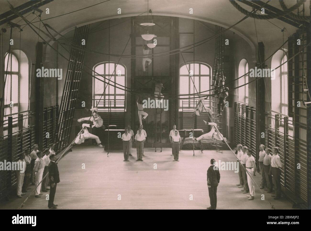 Turnen im Jahr 1916. Ein Interieur eines Gymnasiums an der Johannes-Feuerwehr in Stockholm, wo die Feuerwehrleute trainieren. Sie führen verschiedene Möglichkeiten, um ihre Fähigkeiten im Klettern Leitern und Seilen zu verbessern. Schweden 1916 Stockfoto