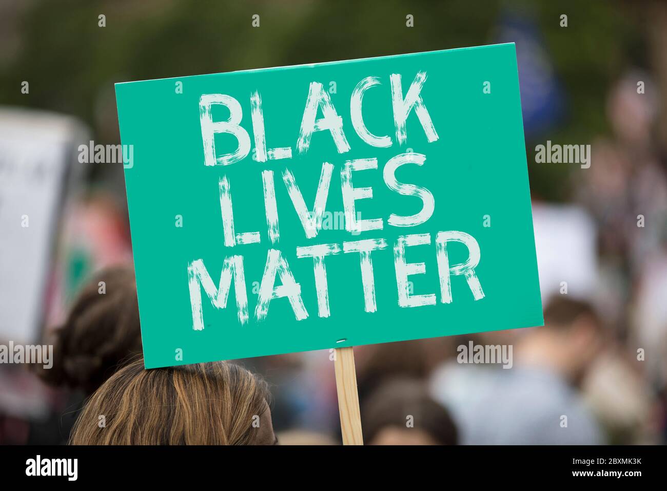 Eine Person, die ein schwarzes Lives Matter Banner bei einem Protest hält Stockfoto