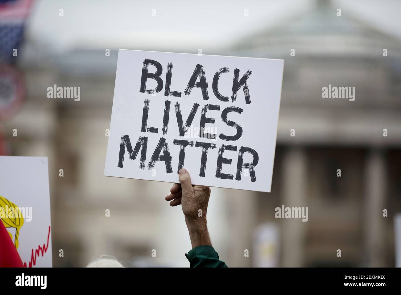 Eine Person, die ein schwarzes Lives Matter Banner bei einem Protest hält Stockfoto