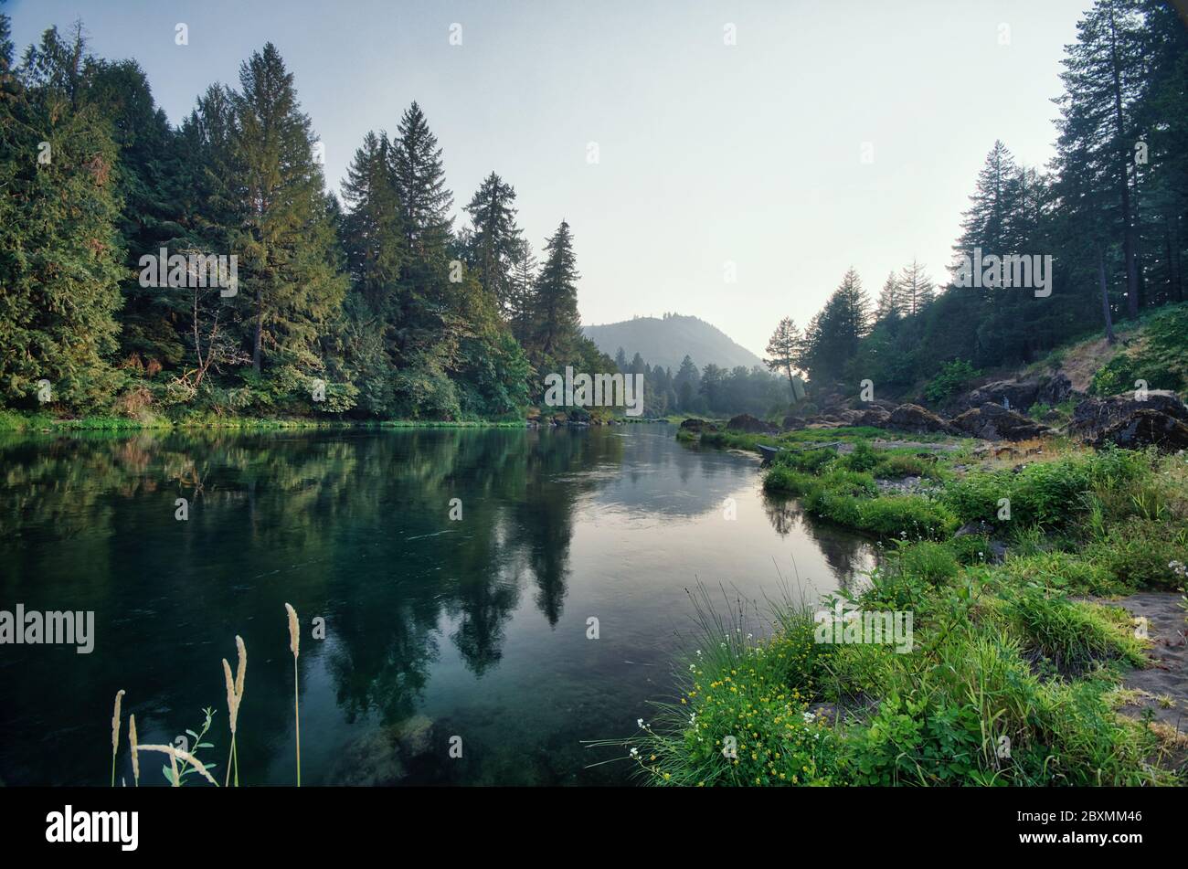 Rauch bedeckt den Horizont am Ende eines Sommertages auf dem McKenzie River in Leaburg, Oregon. Stockfoto