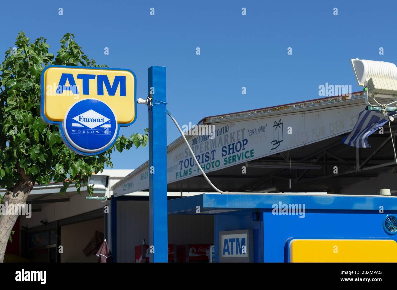 Kolymbia, Rhodos Insel, Griechenland - 24. Mai 2019: Schild mit dem Namen Euronet Worldwide Company und ATM im Hintergrund die Beschilderung von Touristenläden Stockfoto