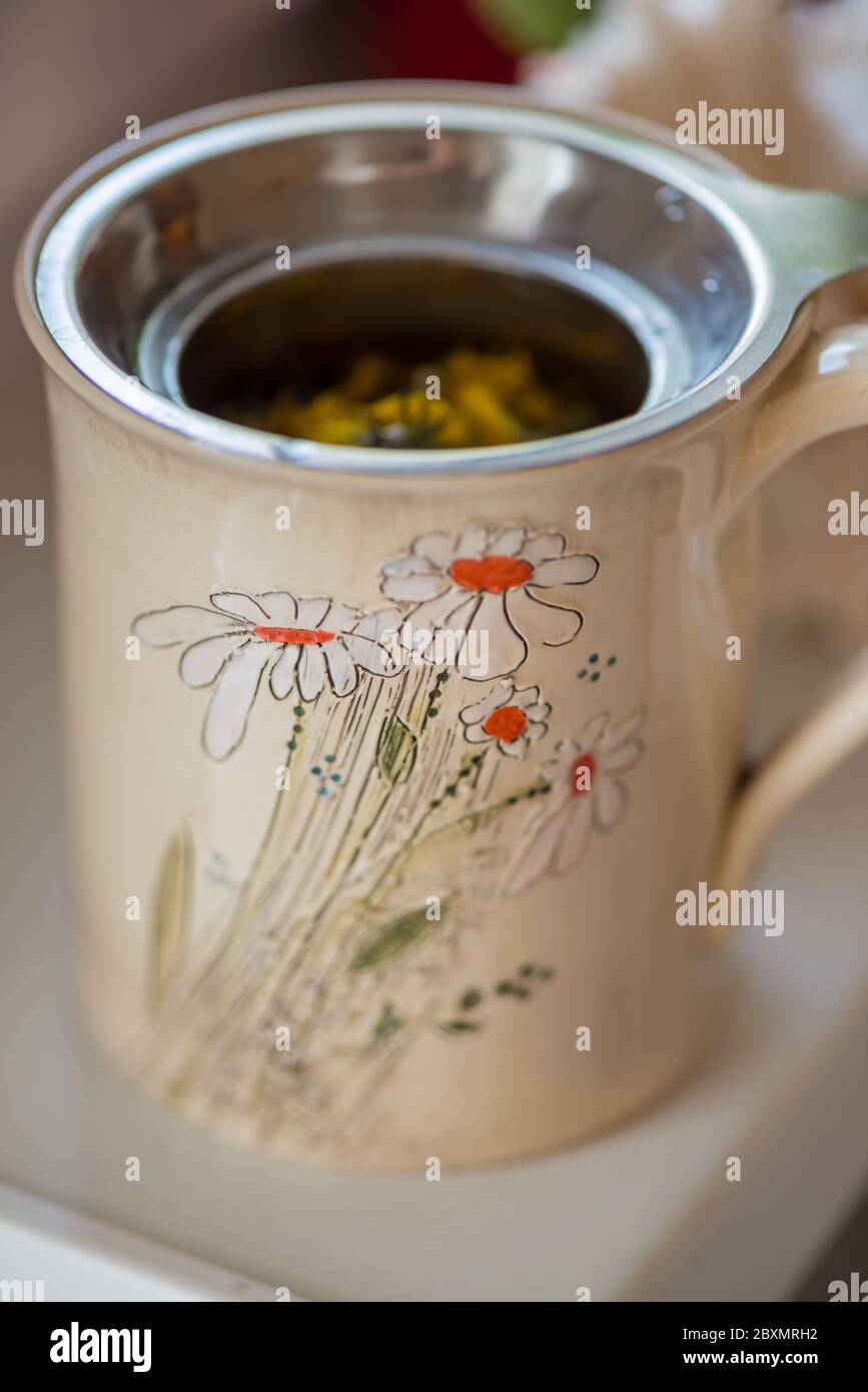 DIY-Konzept. Keramik handgemachte dekorative Tasse mit heißen Kräutertee... Stockfoto