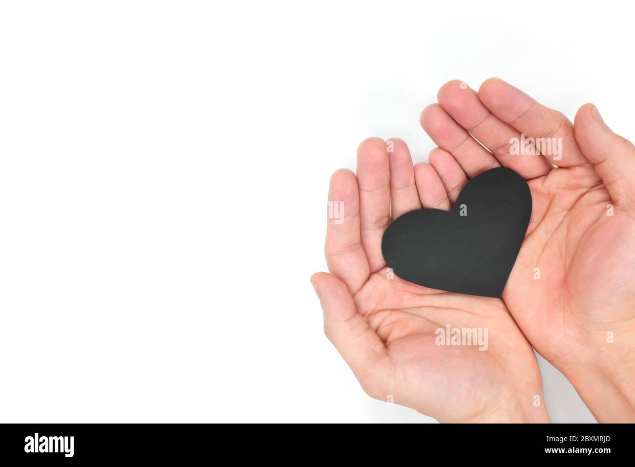 Männliche Hände mit einem schwarzen Herz Draufsicht. Ungesund, Herzerkrankungen, Krebs, Lebensversicherung und Unterstützung schwarzen Leben Bewegung Konzept. Stockfoto