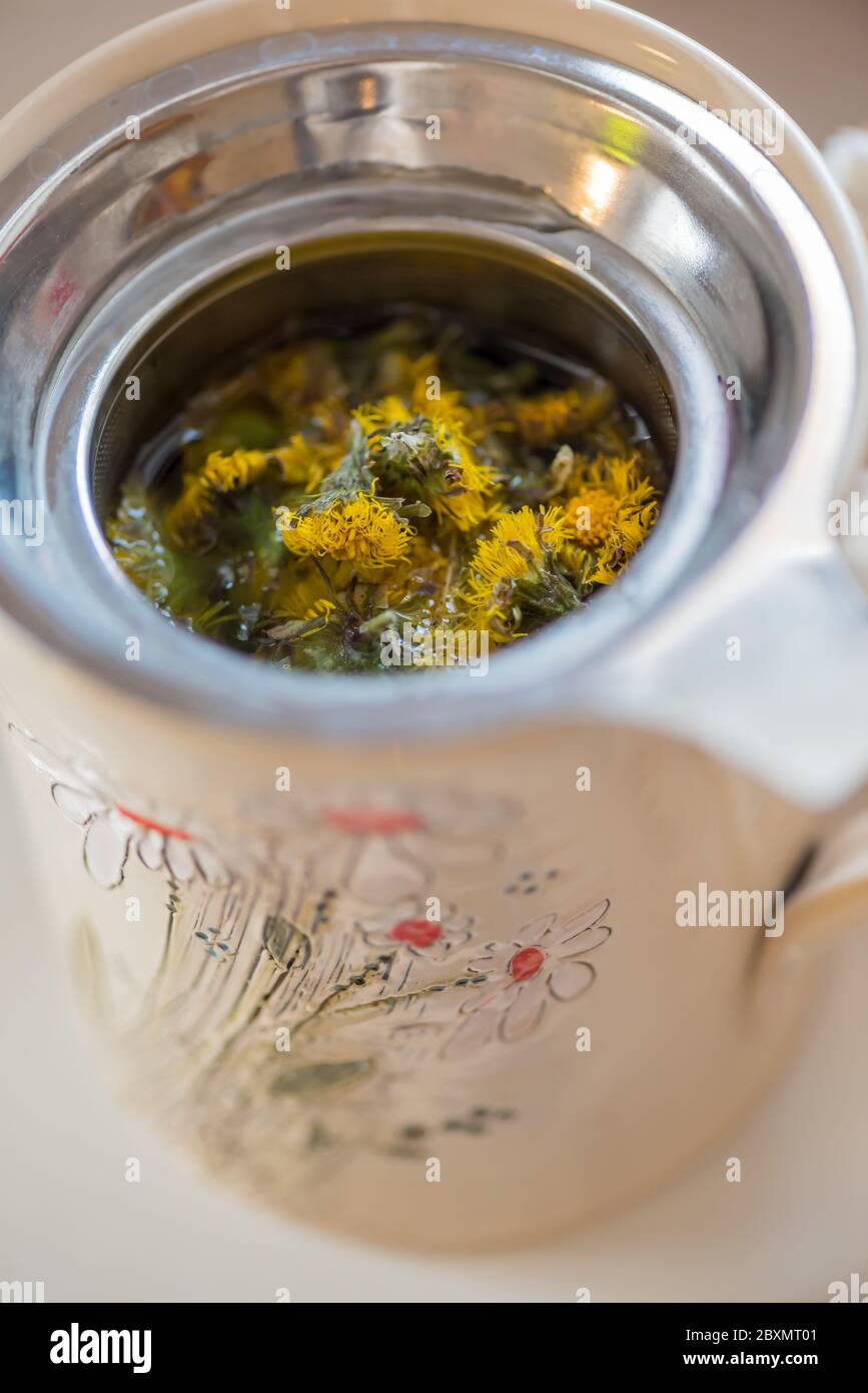 DIY-Konzept. Keramik handgemachte dekorative Tasse mit heißen Kräutertee... Stockfoto