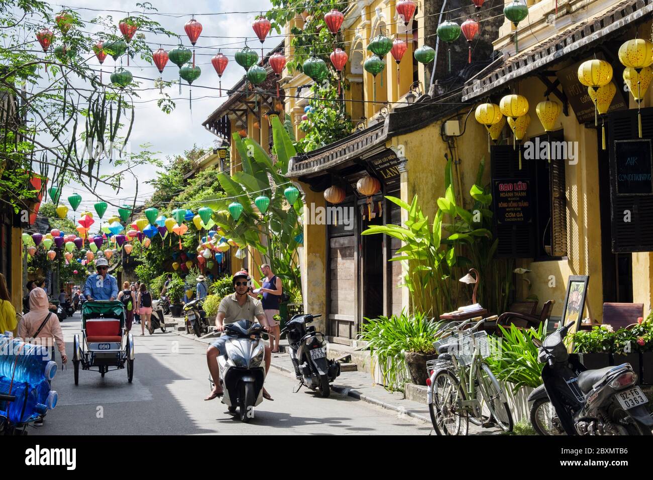 Laternen hängen über einer engen Straße voller Menschen in der Altstadt der historischen Stadt. Hoi an, Provinz Quang Nam, Vietnam, Südostasien Stockfoto