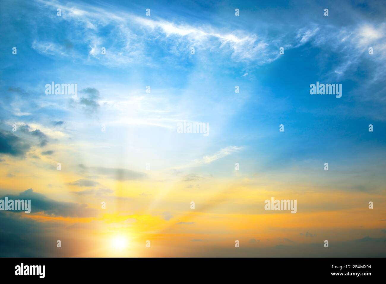 Heller Frühlingsskellung mit blauem Himmel, roter Sonne und Sonnenstrahlen. Stockfoto