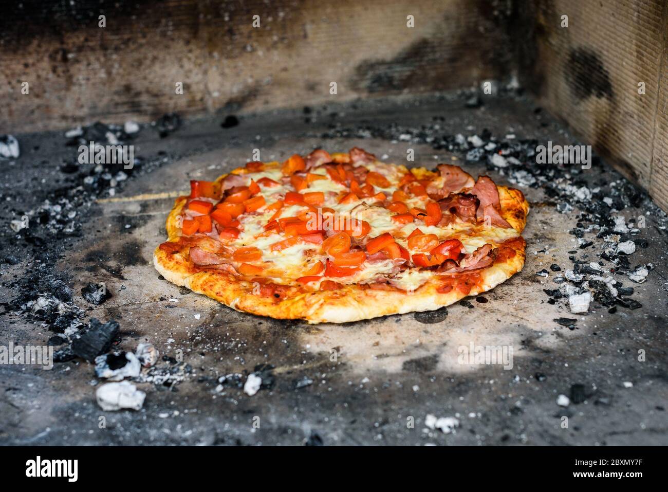Herstellung von hausgemachten italienischen Pizza im Kamin Backstein Ofen. Herstellung von traditionellen Pizza in Stein gemauerten Kamin mit Feuer Holz und Kohlen. Fertig getost Stockfoto