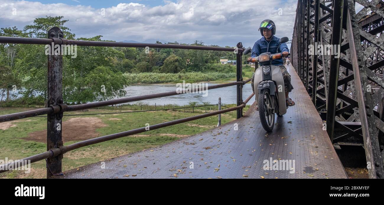 Motorradfahrer überqueren eine alte Eisenbrücke im ländlichen Kuala Kangsar, Perak, Malaysia Stockfoto