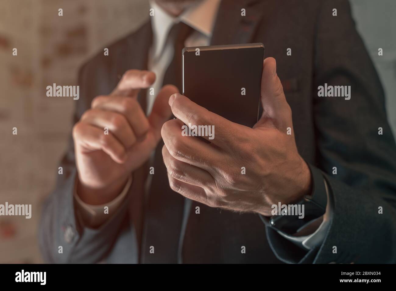 Geschäftsmann mit Handy in gefälschten Nachrichten infodemic Konzept mit Boulevardzeitung Zeitung Seiten im Hintergrund Stockfoto
